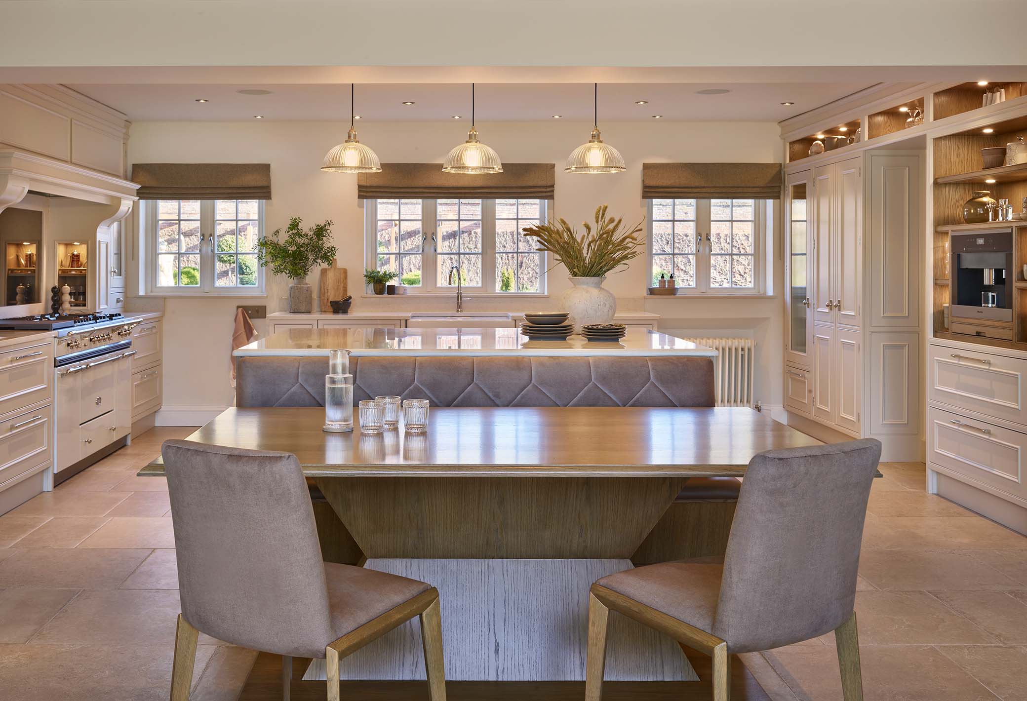 Bespoke kitchen with seating area and Lacanche range cooker in the background