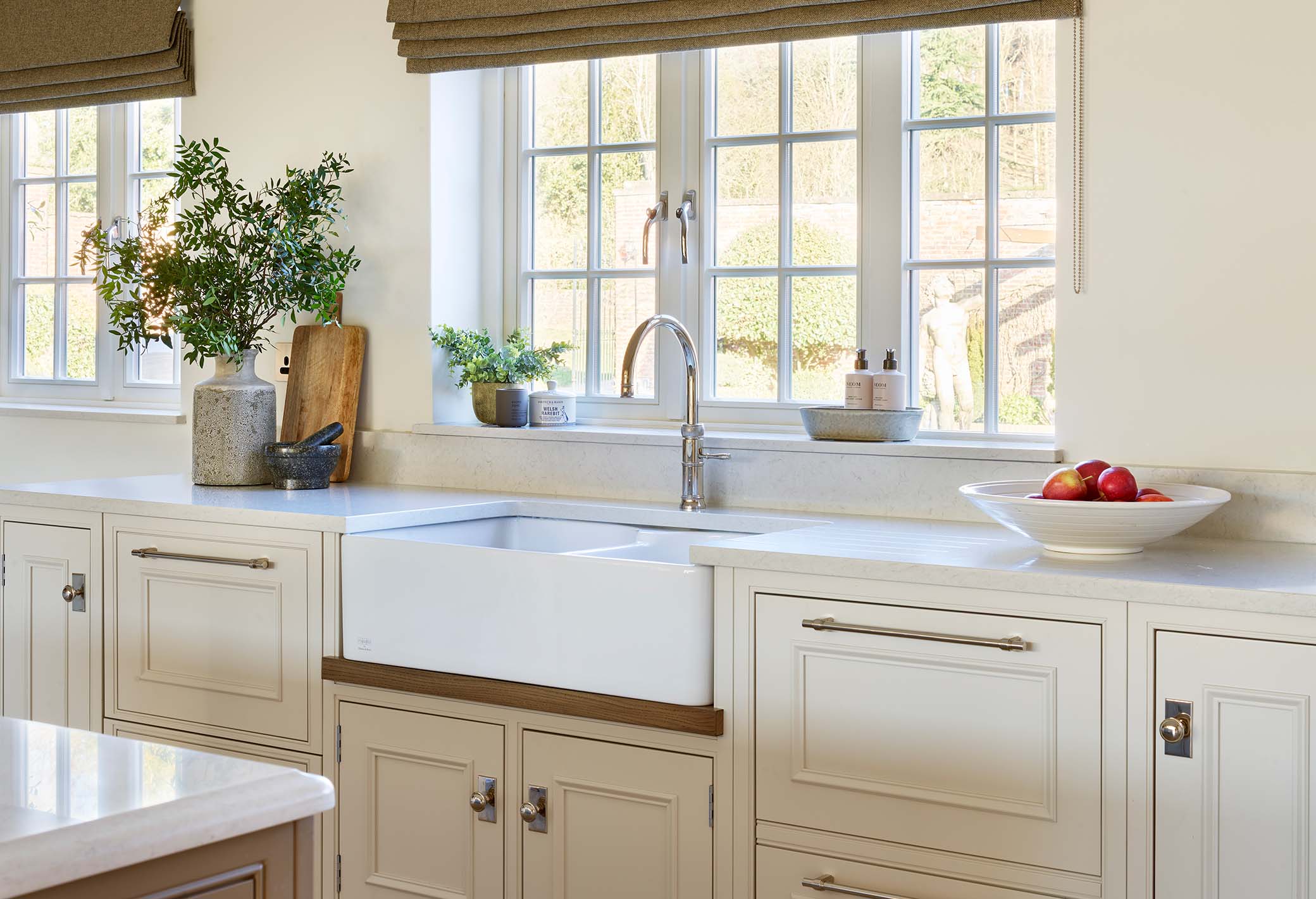 Sink area in a bespoke kitchen with granite worktops and classic cabinetry