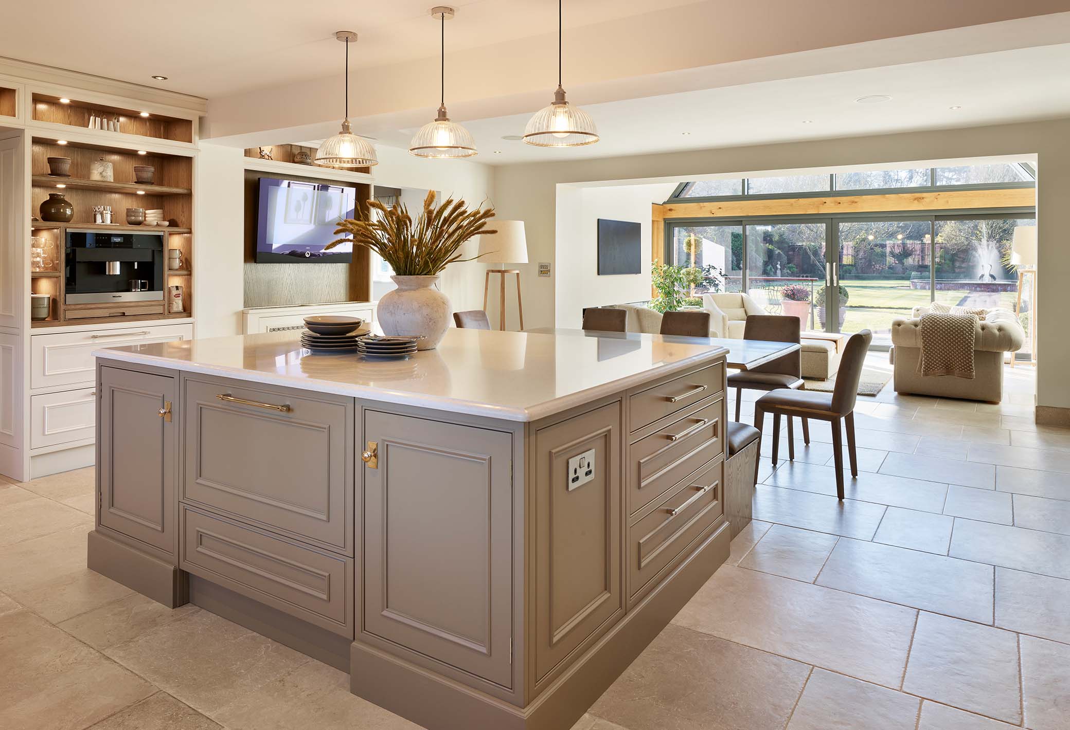 Classic kitchen featuring island, dining space and a living area in the background