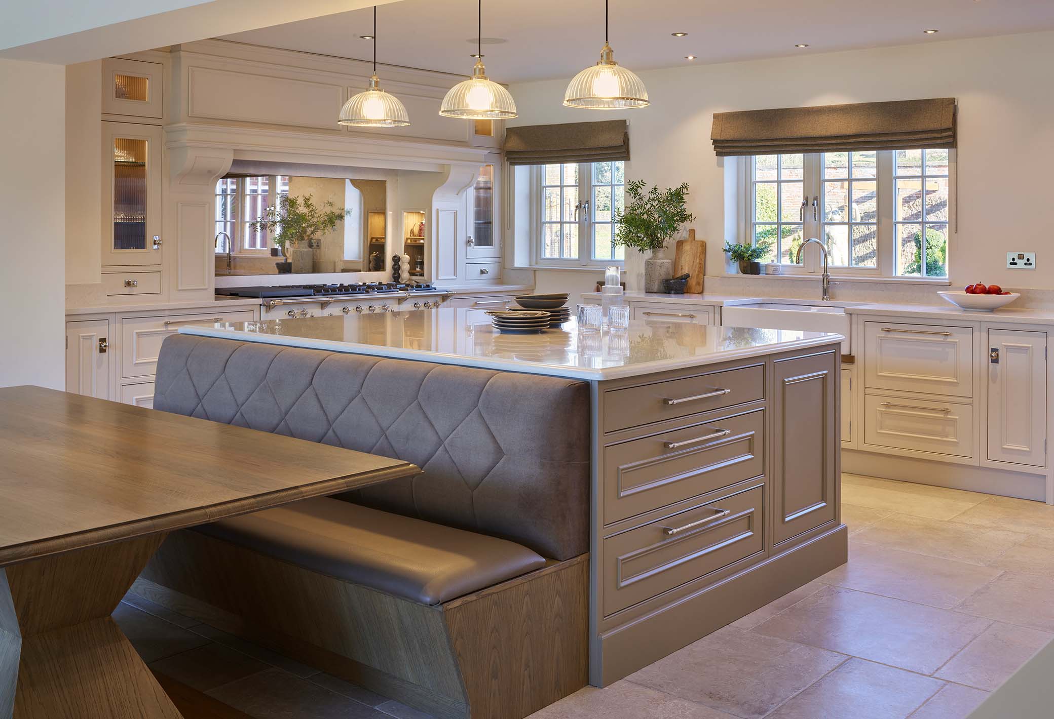 Luxury kitchen with island, seating area and range cooker in the background