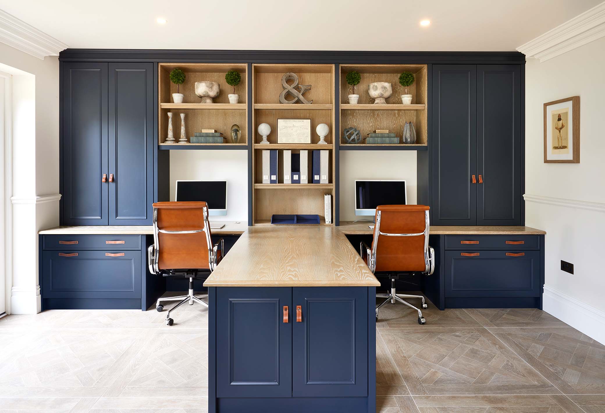 a luxury study with blue cabinetry and matching twin desks
