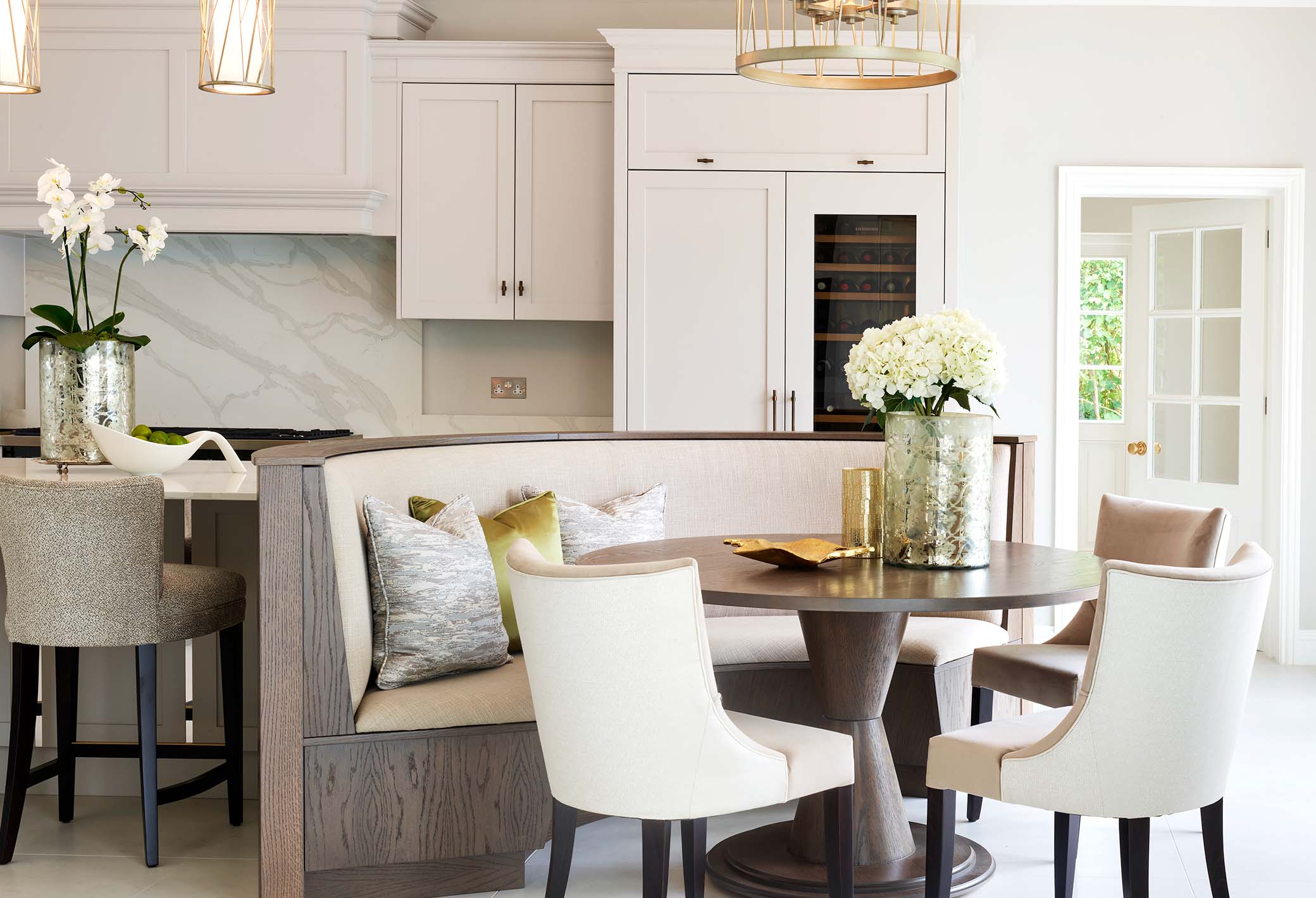 wood panelled curved luxury kitchen dining area with table and chairs