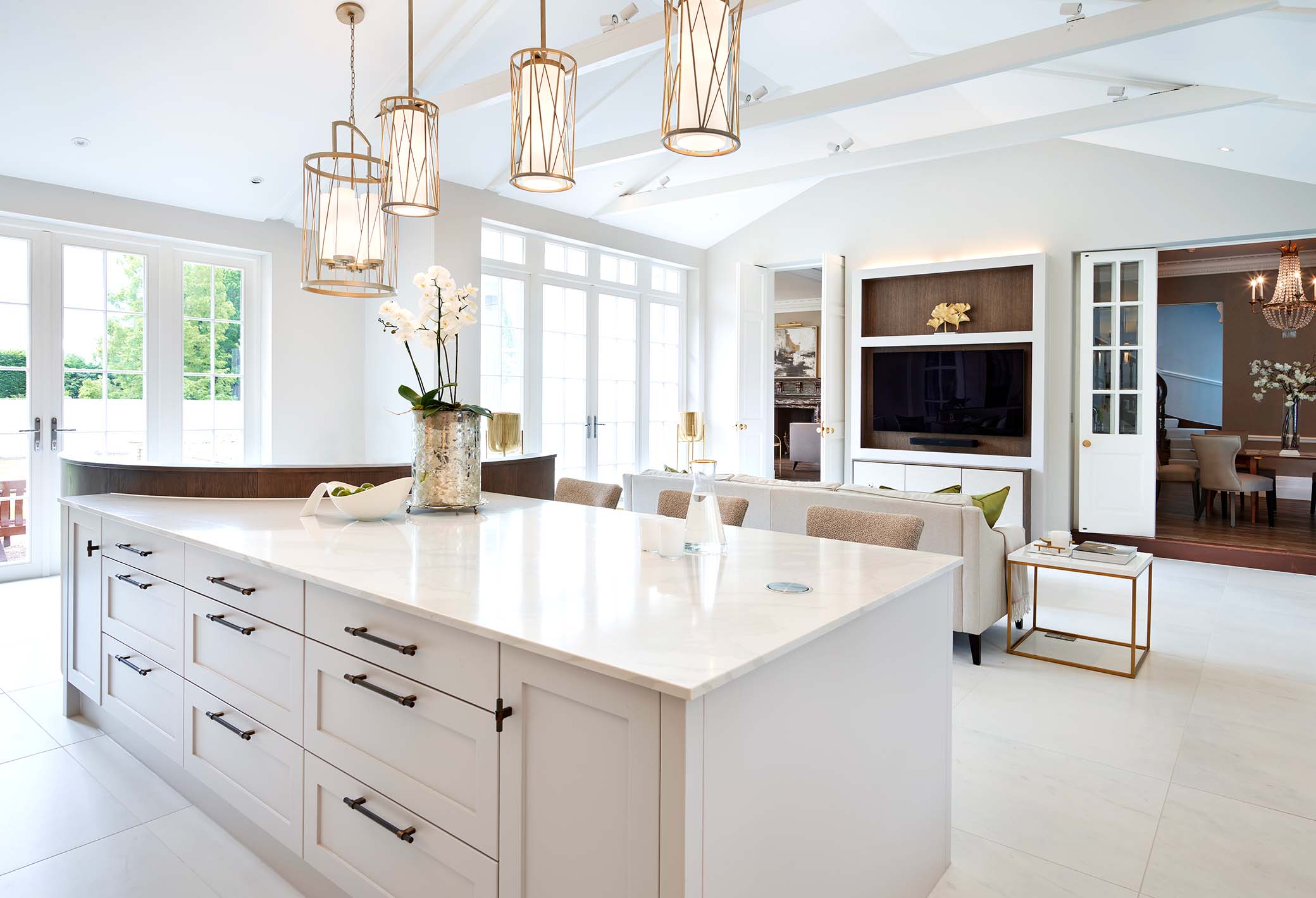 kitchen island with marble worksurface, tv media wall and seating area in the background