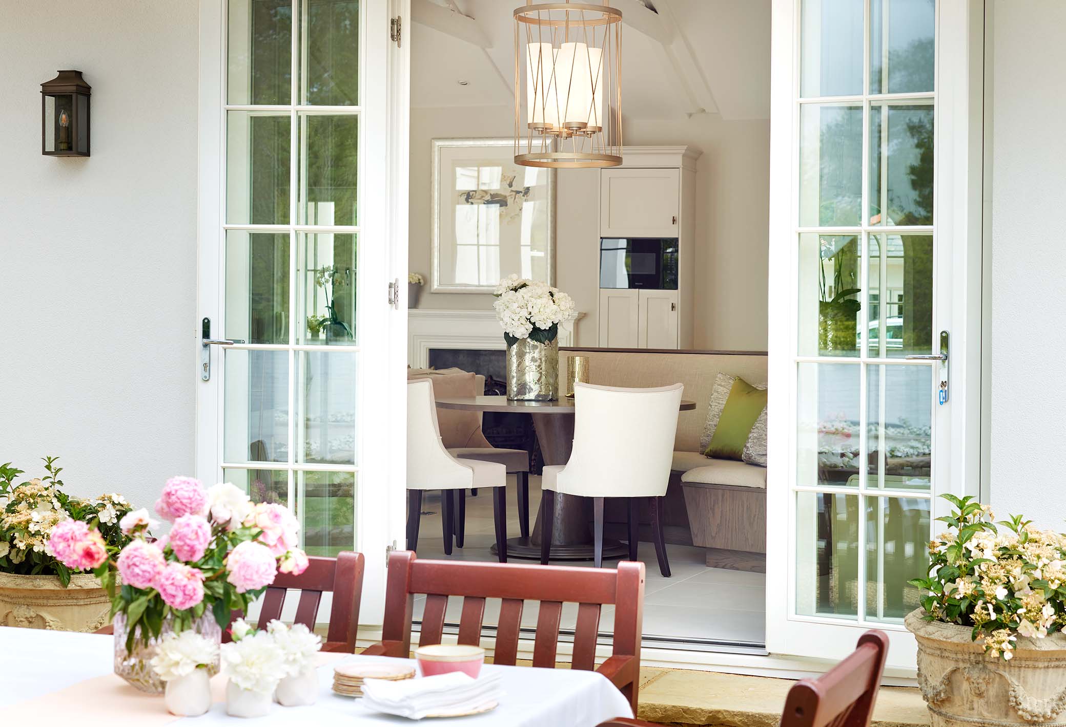 outside seating and dining area with open doors behind looking in to a custom kitchen in perthshire scotland
