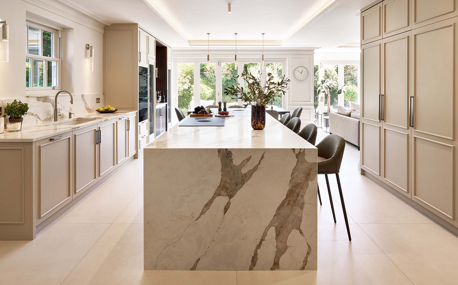 Bespoke contemporary Shaker kitchen design in Cambridge by Charles Yorke, featuring a luxury marble-veined waterfall island, minimalist cream cabinetry, and modern bar stools.